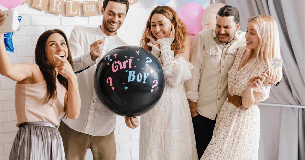 A pregnant couple surrounded by friends celebrating during a gender reveal party.